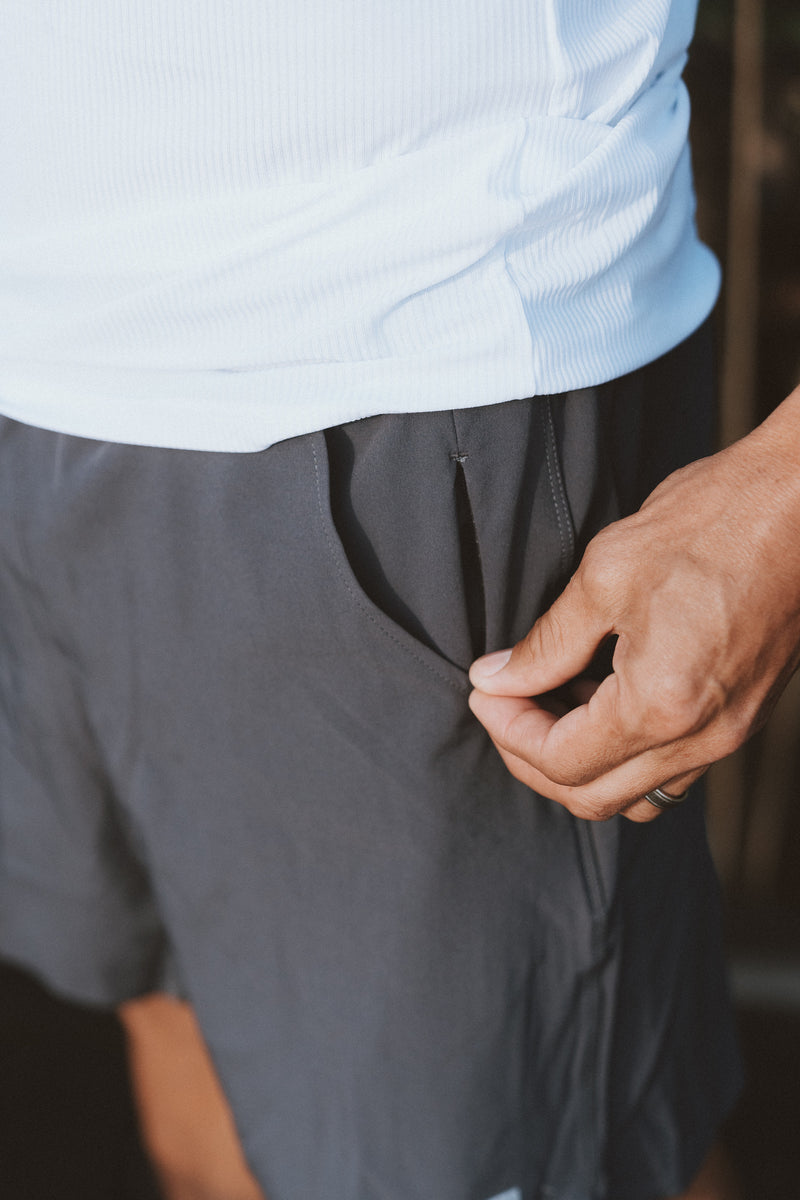 Model showing the hidden zipper pocket in the charcoal Rep Shorts. The perfect athleisure shorts for men.