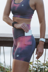 Model placing a phone in the side pocket of Ethereal Little Bit Longer Shorts. Women's running shorts with pockets.