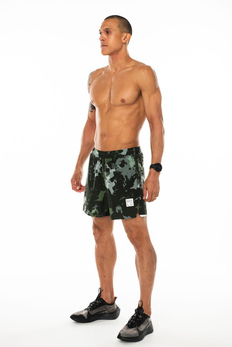Left view men's Noosa Run Short. Mid-thigh camo run shorts with reflective logo and stripe on left thigh.