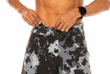 Model placing keys in small waistline pocket of Arvo Shorts. Camo running shorts with pockets.