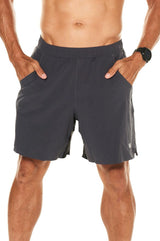 Model with his hands in the pockets of charcoal Rep Shorts. Men's gym shorts that double as casual wear.