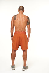 Back view of men's Arvo Shorts. Rust colored gym shorts with a 9.5" inseam and 4-way stretch waistband.