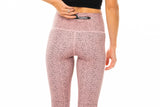 Model placing keys in back zipper pocket of cheetah print leggings. Hi Rise Luxe leggings.
