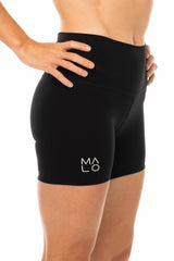 Right view model wearing black athleisure shorts. Mid-thigh running shorts that are quick drying and breathable.
