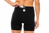 Model placing a nutrition gel in back pocket of black running shorts. Workout shorts that hold your belongings