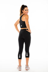 Back view Pacer 3/4 Leggings. Black leggings with reflective logo. Mid-calf length yoga pants.