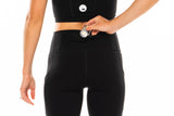 Model placing keys in back pocket of black leggings. Pacer 3/4 Leggings with pockets.