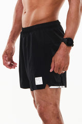 Left view men's Noosa Run Short. Black run shorts with reflective logo and stripe on left thigh.