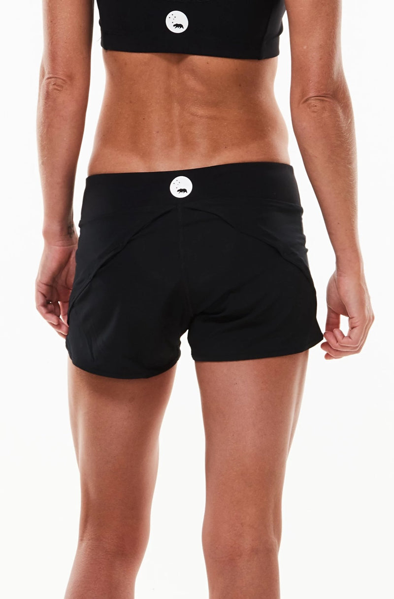 Back view Run The World Shorts. Black athleisure shorts with reflective logo. Relaxed fitting shorts.