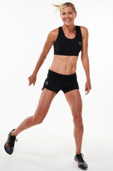 Model wearing Run The World Shorts with matching sports bra. Running shorts with low waistline.
