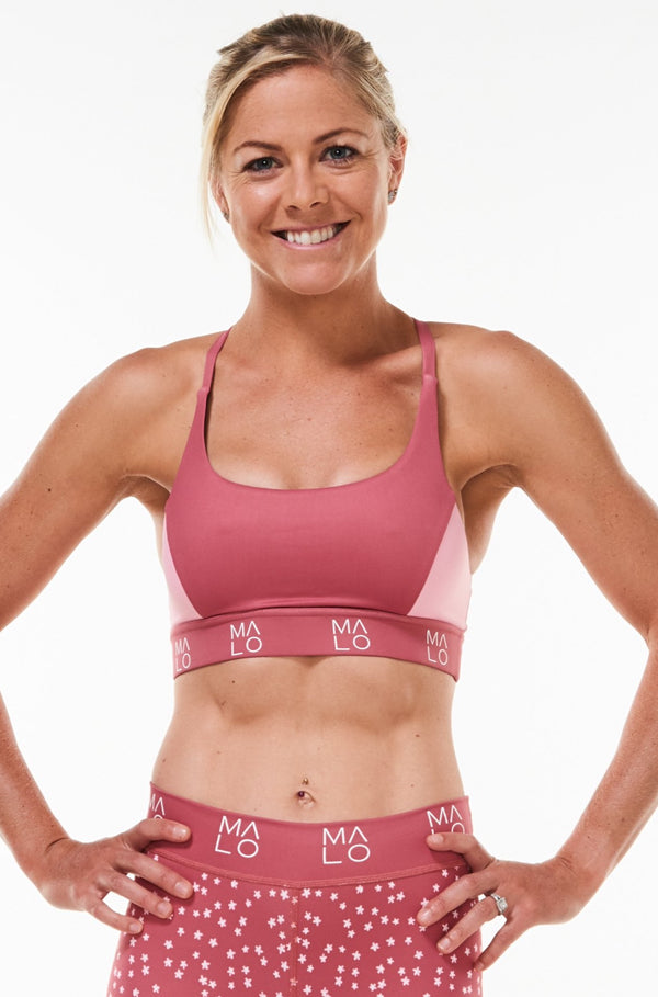 Model wearing pink Sunshine Bra with matching leggings. Performance sports bra to keep you cool and comfortable.