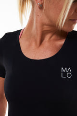 Close view of Women's Edge Performance Tee. Black workout shirt with white 'MALO' logo on left side.