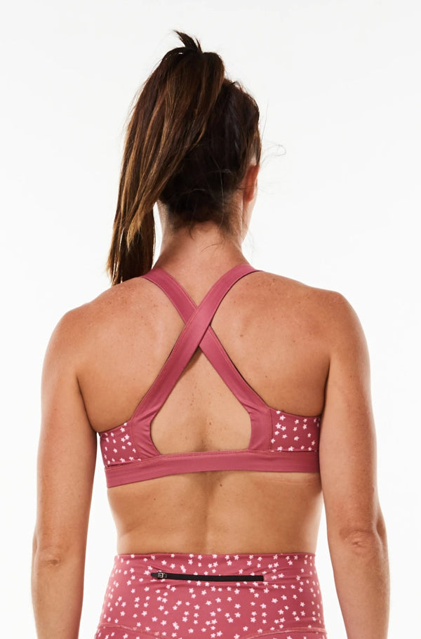 Do It Now Bra. Pink sports bra with cross straps in the back for support.
