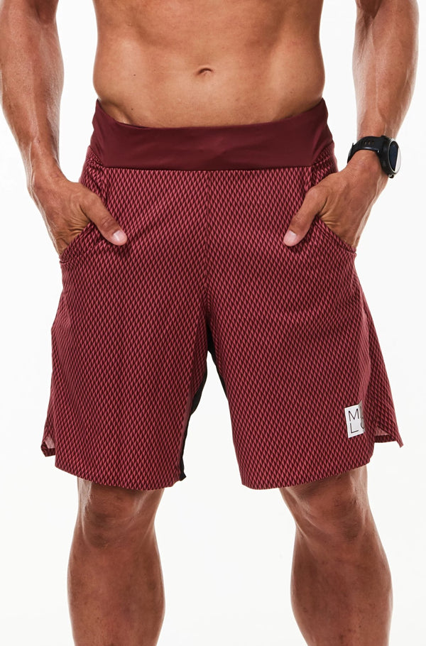 Model with hands in pockets of Arvo Shorts. Red workout shorts with pockets and comfortable waistline.
